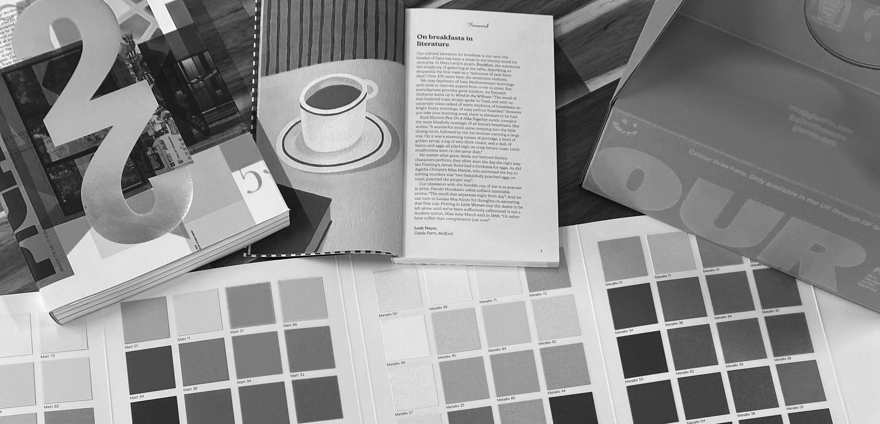 Colour swatch books and print references on a studio desk